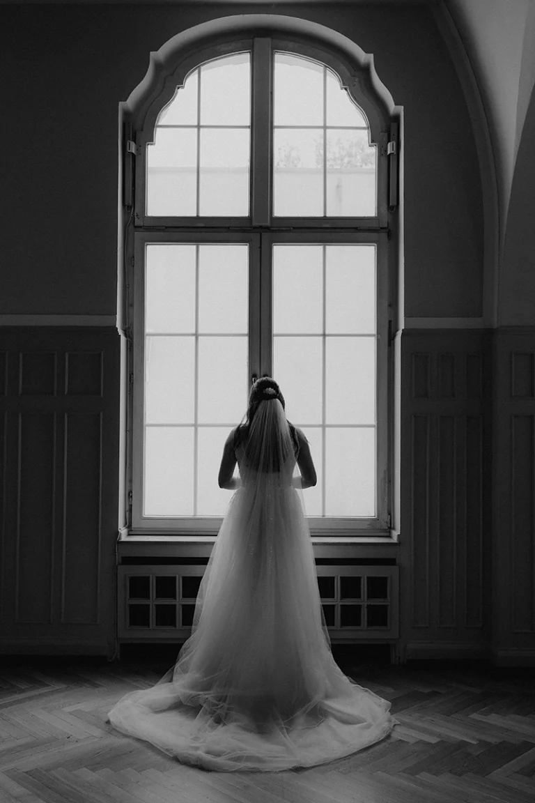 Braut steht beim getting Ready vor dem Fenster Hochzeitsfotograf Köln Hochzeitslocation Stadtgarten Essem